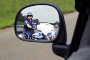 Driver Looking at the Police Motorcycle Officer in the Side Mirror — Fayetteville, NC — Britt Carl L Jr